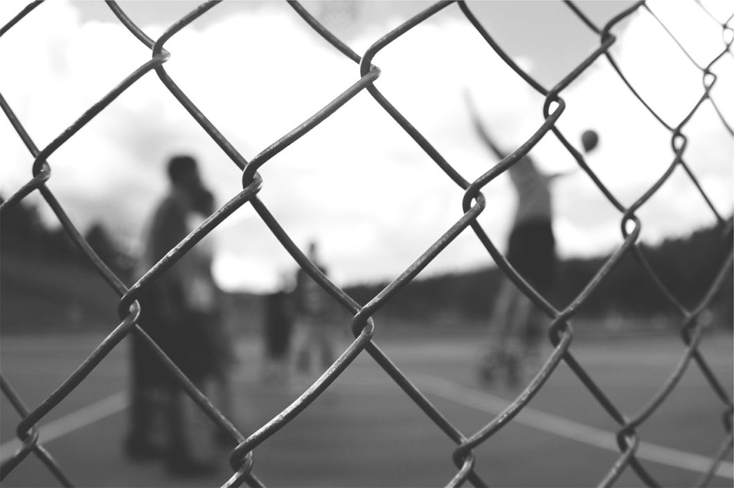 Feeling Depressed After Sports Retirement | Photo of a fence in front of a basketball court