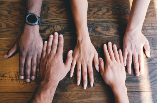 Athlete Peer Groups article - image shows hands together - Photo by Clay Banks on Unsplash