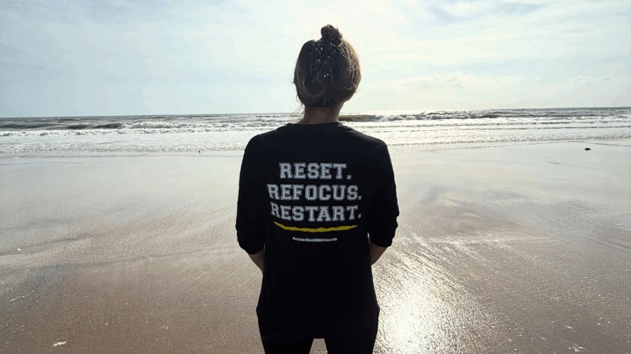 Person wearing Reset Refocus Restart Shirt on Beach Athlete Mindfulness