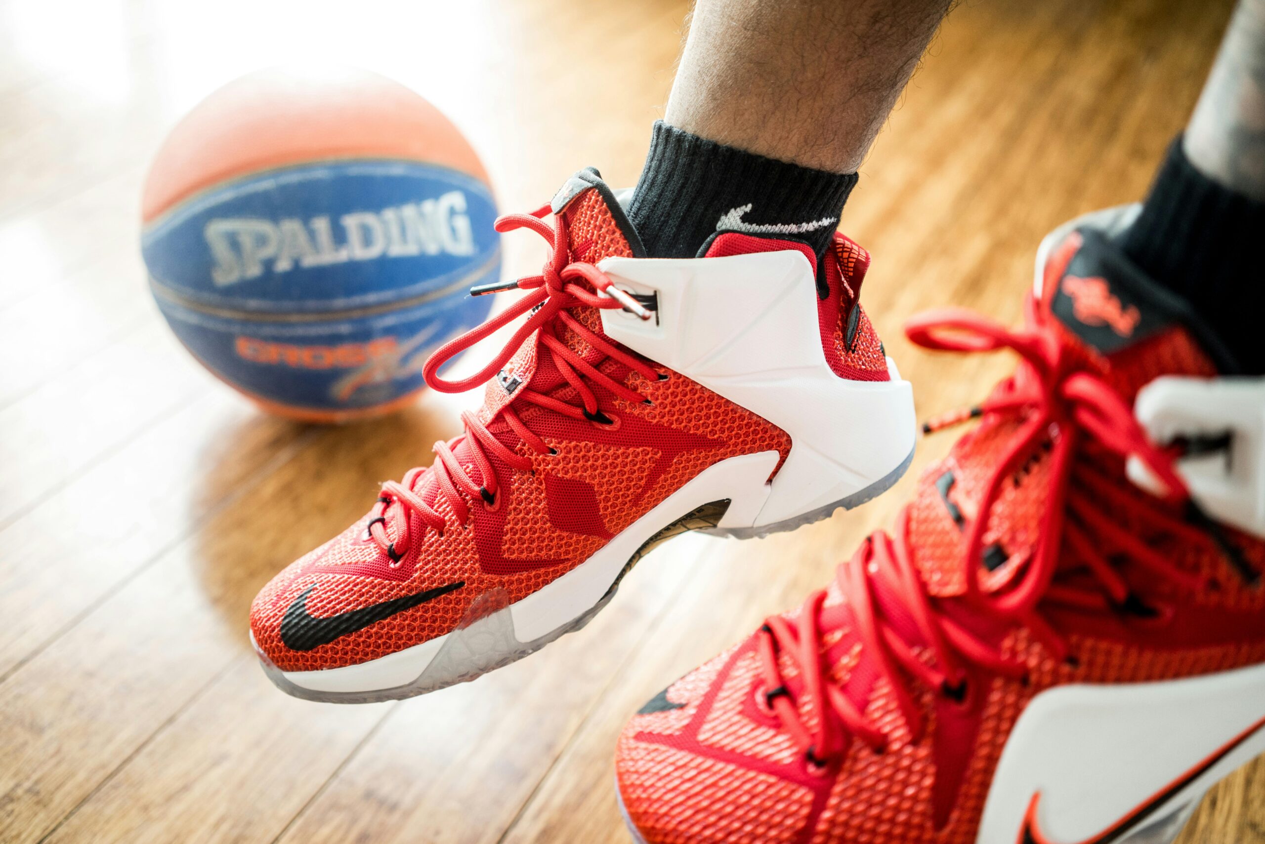 Why Nike’s “Why Do It?” Campaign Hits at the Heart of Athlete Mental Health | Person Wearing Pair of Red-and-white Nike Lebron 12 Shoes with Basketball